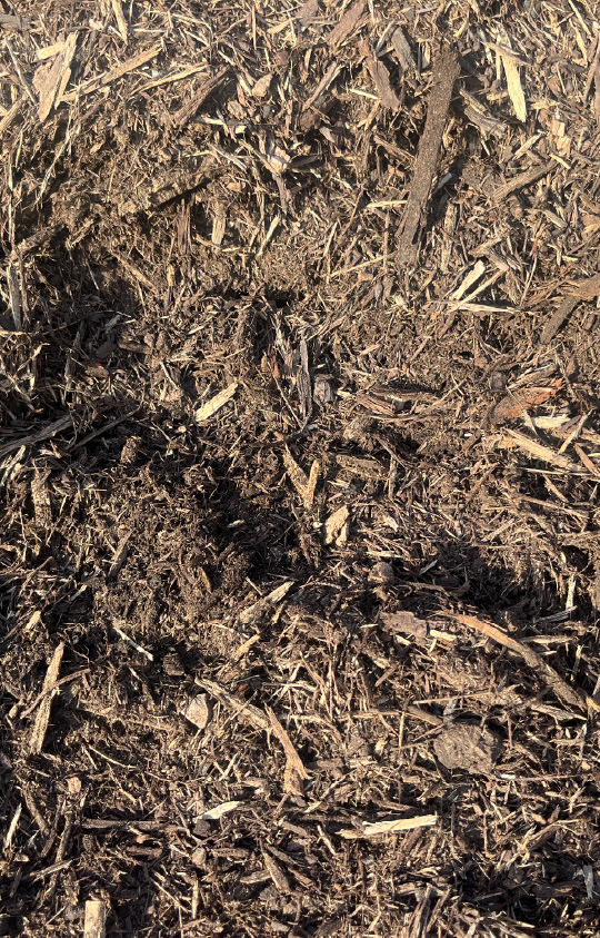 Close-up of natural hardwood mulch with a rich brown tone, ideal for garden beds and landscaping to improve moisture retention and curb appeal.